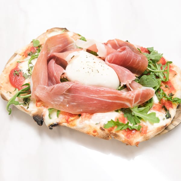 Johnny & Sanny's Italian pizza topped with prosciutto, burrata, arugula, and tomato sauce.